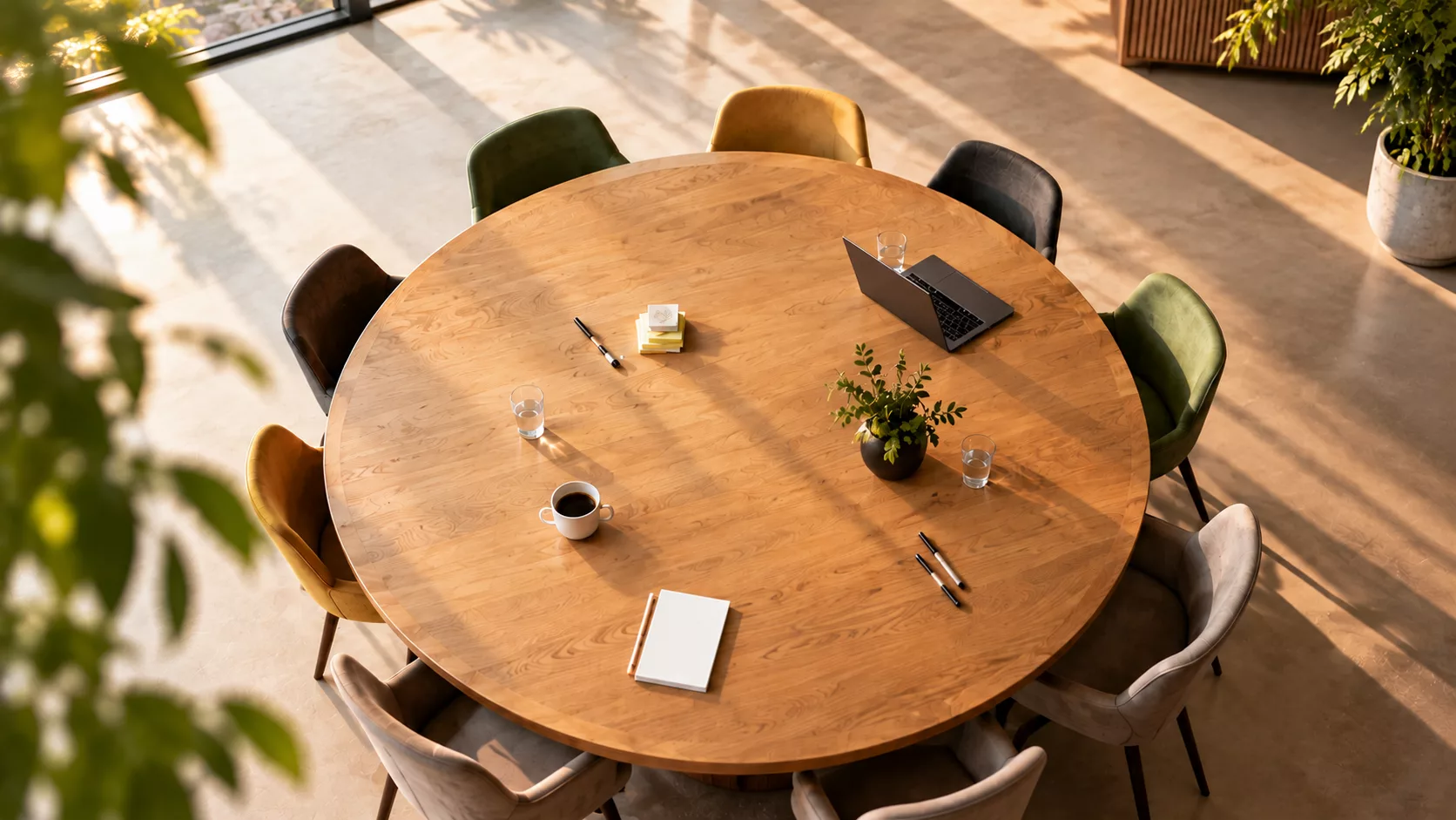 Van boven gezien: een ronde houten tafel met open plekken voor een gesprek.